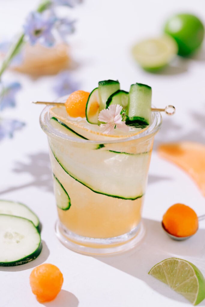 cucumber melon cocktail garnished with cucumber ribbons and cantaloupe