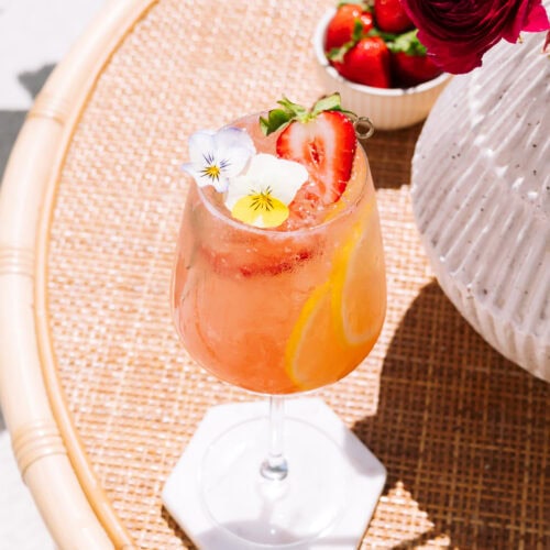 strawberry limoncello spritz on table with flowers in vase