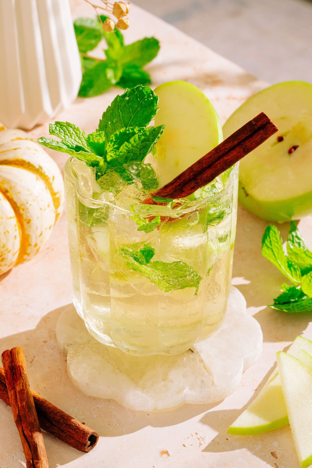 Non-alcoholic hugo spritz in glass with apples, mint and cinnamon