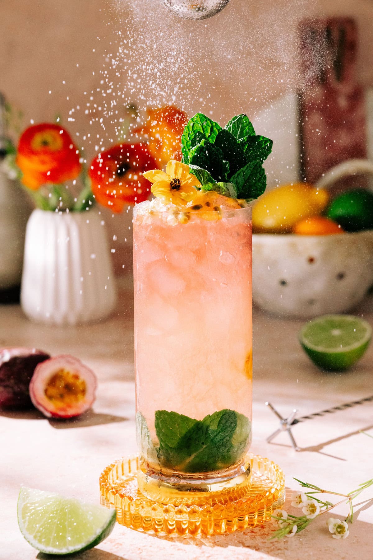 Passion Fruit Swizzle Mocktail (With Hibiscus Tea) garnished with mint leaves and flying powered sugar.