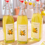 3 Bottles of homemade limoncello recipe with labels with lemons