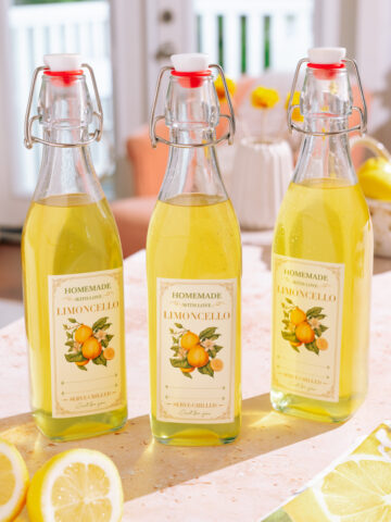 3 Bottles of homemade limoncello recipe with labels with lemons