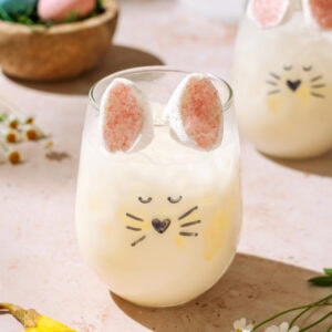 Easter Bunny Spritz creamsicle cocktail with bunny marshmallow ears in a festive Easter glass.