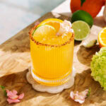 Refreshing hot honey citrus mockarita with sumo orange, lime, and chili sugar rim on ice