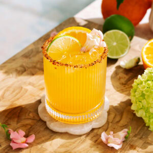 Refreshing hot honey citrus mockarita with sumo orange, lime, and chili sugar rim on ice