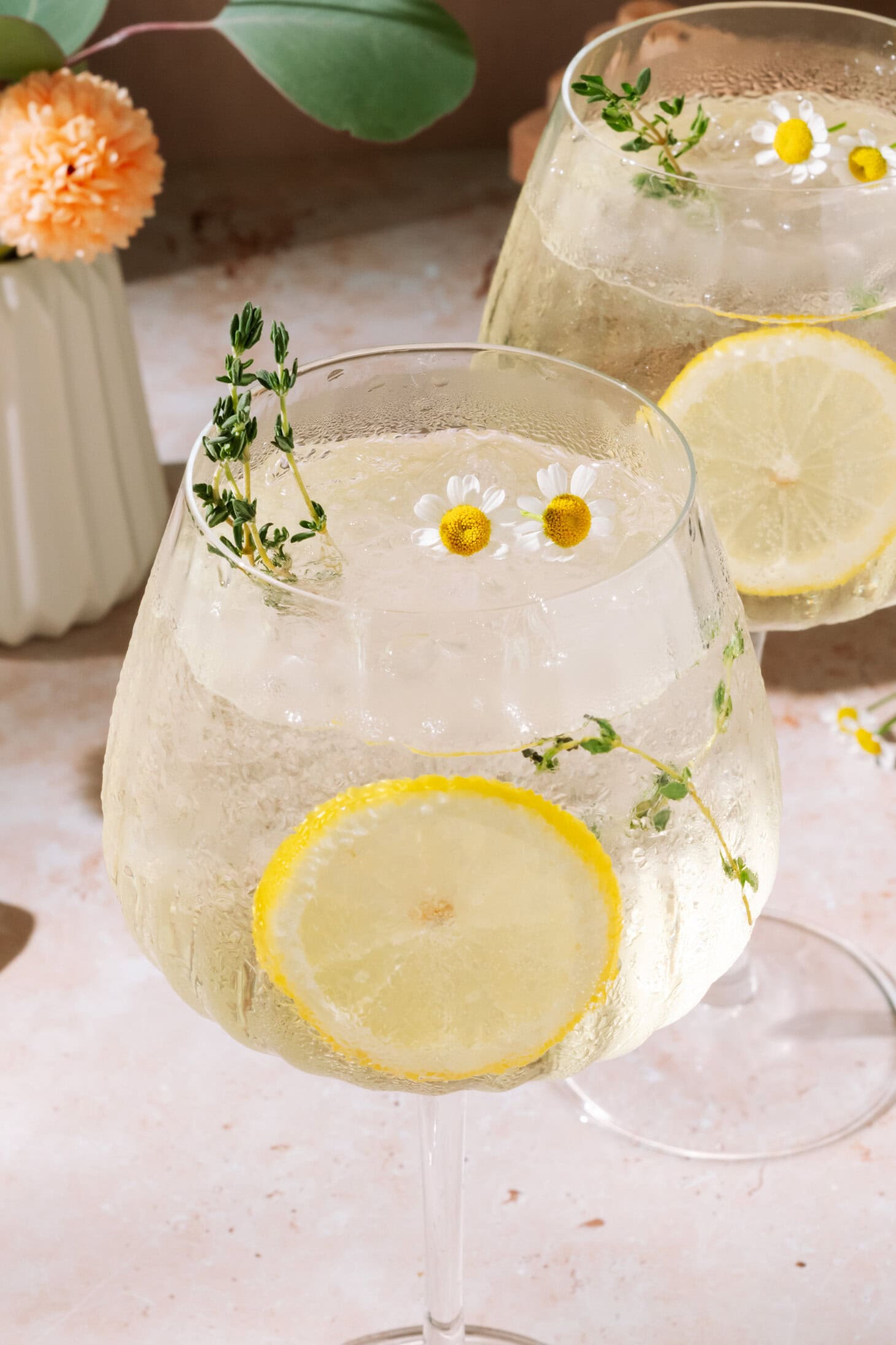 Limoncello Spritz with fresh lemon slices and floral herb garnish.