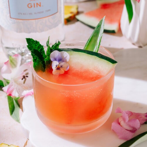 Tropical Watermelon Gin Cocktail garnished with fresh watermelon and lime and mint.