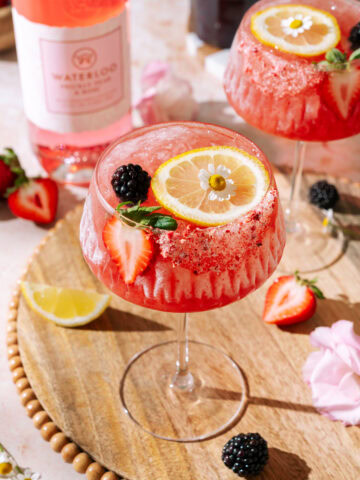 Sunday Jam gin and jam cocktail garnished with fresh strawberries, blackberries, lemon and edible flowers.