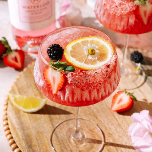 Sunday Jam gin and jam cocktail garnished with fresh strawberries, blackberries, lemon and edible flowers.