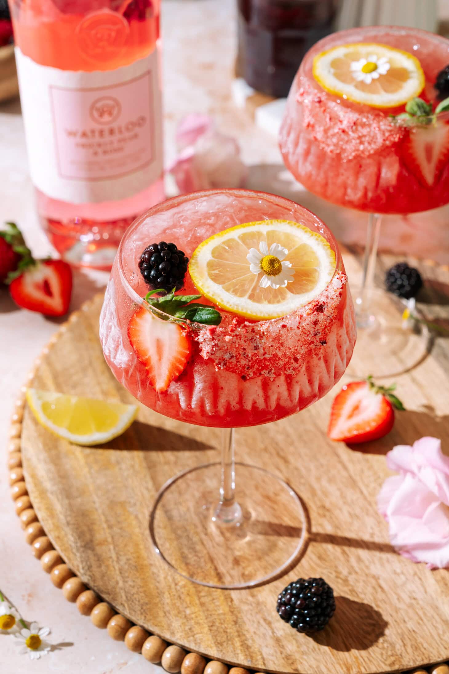 Sunday Jam gin and jam cocktail garnished with fresh strawberries, blackberries, lemon and edible flowers.