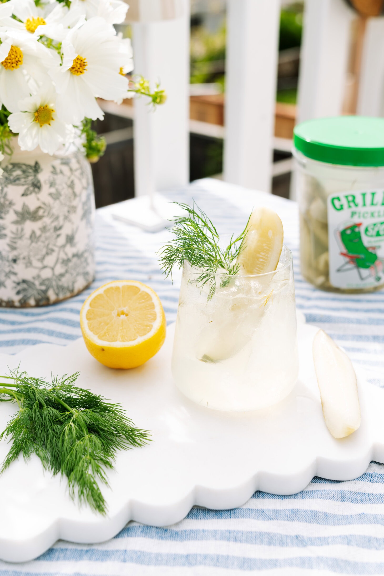 Pickle Spritz in a short glass, garnished with a pickle slice, fresh dill, and lemon.